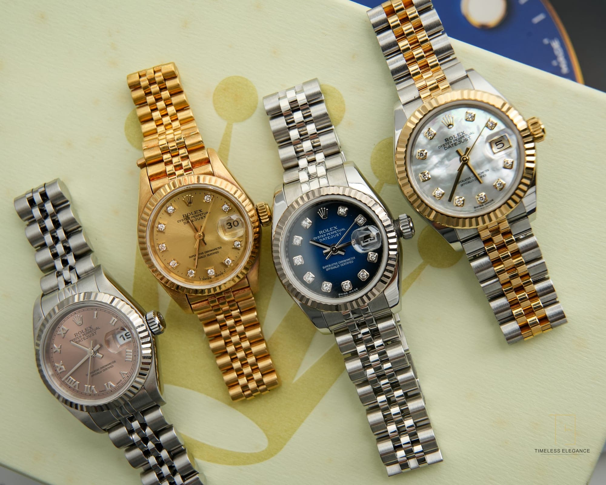 Three Rolex Datejusts laid side by side — yellow gold, steel with blue dial, and two-tone with mother-of-pearl