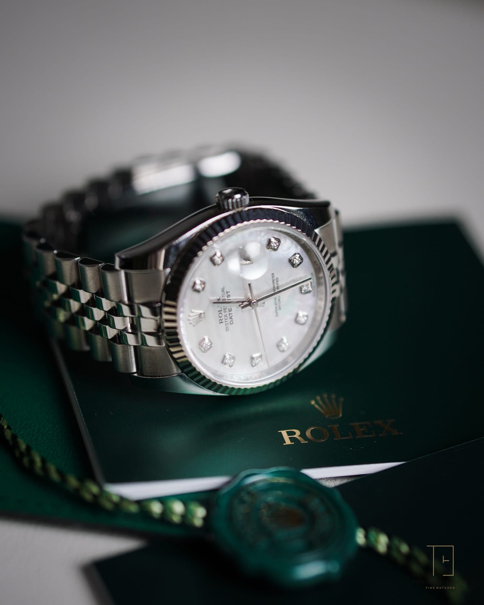 A Rolex Datejust with mother-of-pearl diamond dial, shown with its green box and papers