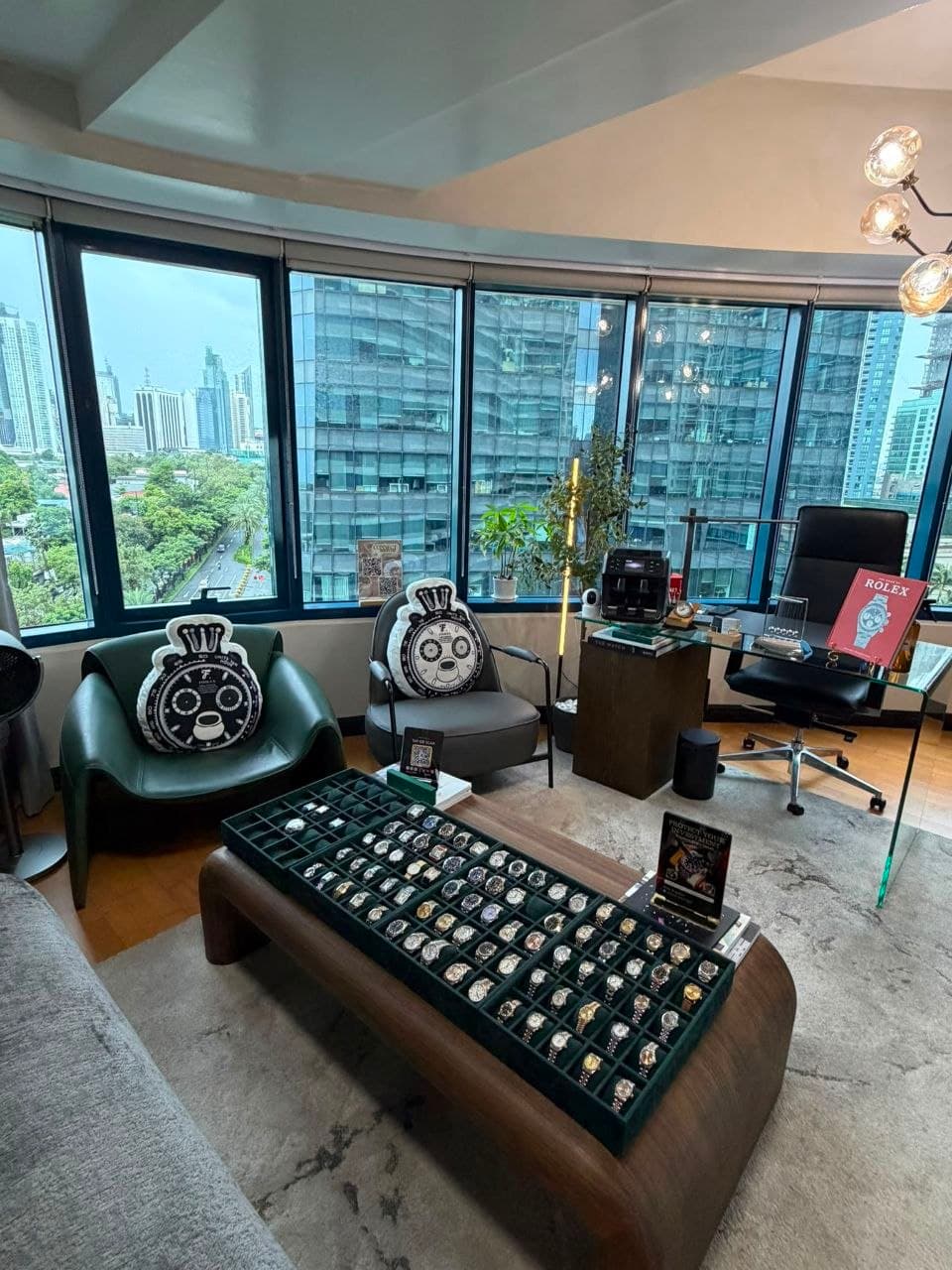 The Rockwell showroom, watch trays on the centre table with the Makati skyline beyond